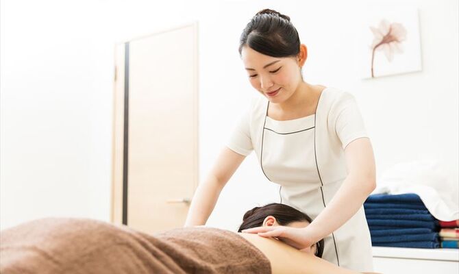肩甲骨周辺の施術を行うスタッフ